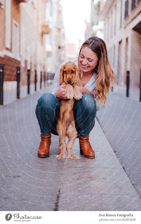 young woman at the street hugging her cute cocker dog. Lifestyle outdoors with pets walking city urban purebred caucasian coker lifestyle friendship beautiful