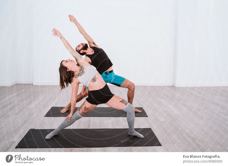 young man and woman practicing yoga sport at the gym. Healthy lifestyle boy health healthy indoors studio white hispanic sportive power professional male person