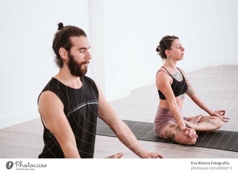 young man and woman practicing yoga sport at the gym. Healthy lifestyle boy health healthy indoors studio white hispanic sportive power professional male person