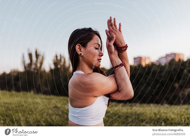 young beautiful asian woman doing yoga in a park at sunset. Yoga and healthy lifestyle concept. summer happy enjoyment sport sportive relax relaxation field