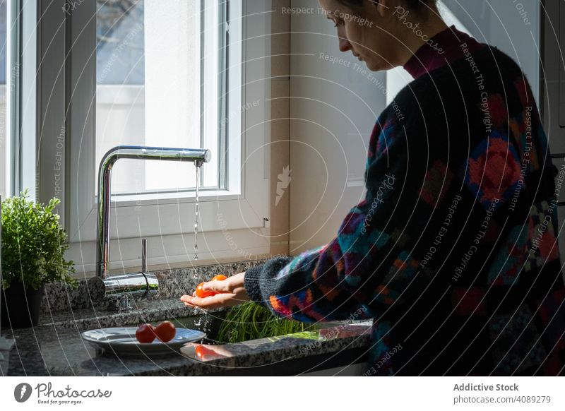 Woman washing tomato over sink woman water kitchen home tap fresh ripe vegetable food healthy clean wet diet female ingredient faucet lifestyle vitamin hygiene