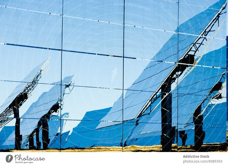Reflection of solar panels on glass wall power station reflection shiny sunny cells daytime energy electricity technology weather photovoltaic ecology renewable
