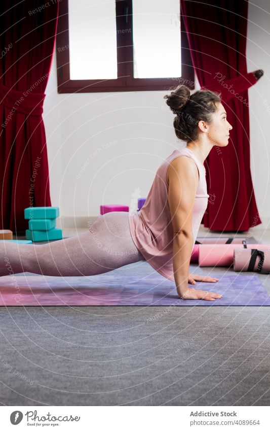 Young attractive woman practicing yoga indoors young flexible sportive concentrated pose lying sportswear brunette relaxation meditation fitness mat healthy