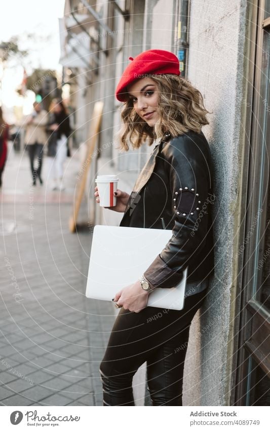 Woman with drink on the street woman city building takeaway cup stylish young female beret outfit beverage takeout lady leaning wall to go coffee tea trendy