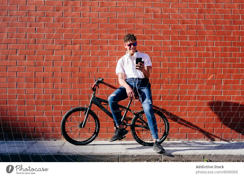 Young happy black male browsing smartphone on bike man bicycle using relax hipster lifestyle young african american ethnic smiling joy cheerful sport activity