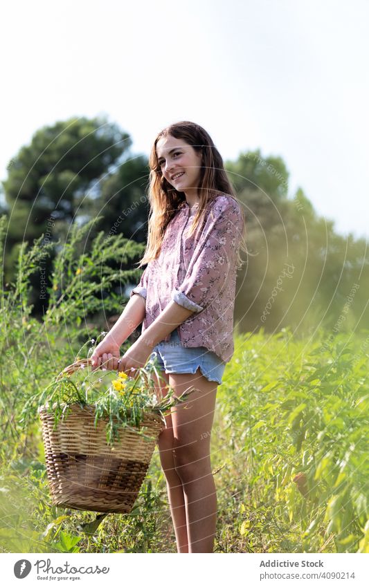 Smiling teen girl with basket of herbs teenager farm smiling looking away field catalonia spain anoia sunny daytime casual harvest lifestyle nature green