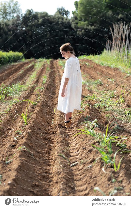 Anonymous teenager walking on farm field sprouts balancing summer nature outstretched arms sunny daytime catalonia spain anoia girl young rural rustic
