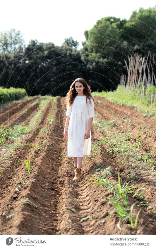 Teenager walking on farm field teenager sprouts summer nature sunny daytime catalonia spain anoia girl young rural rustic agriculture seedlings saplings