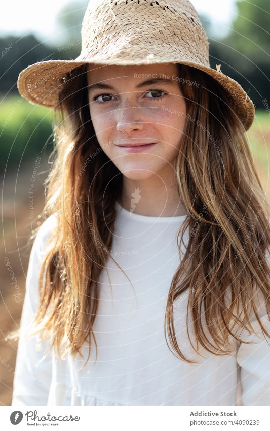 Portrait of teenager with hat on filed portrait looking at camera field farm sprouts summer nature sunny daytime catalonia spain anoia girl young rural rustic