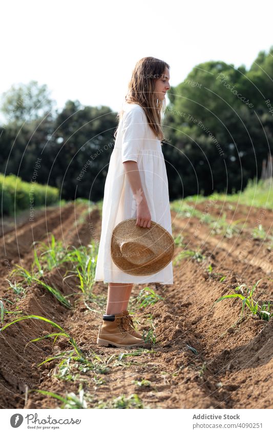 Teenager walking on farm field teenager hat sprouts balancing summer nature outstretched arms sunny daytime catalonia spain anoia girl young rural rustic