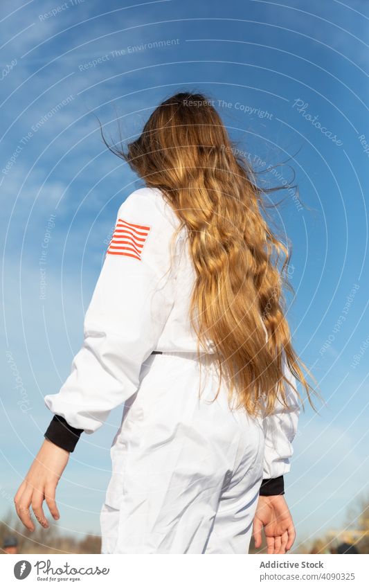 Cheerful teenager back view wearing american uniform girl sky clouds sunny daytime happy excited cheerful joy lifestyle leisure rest relax kid child amazed