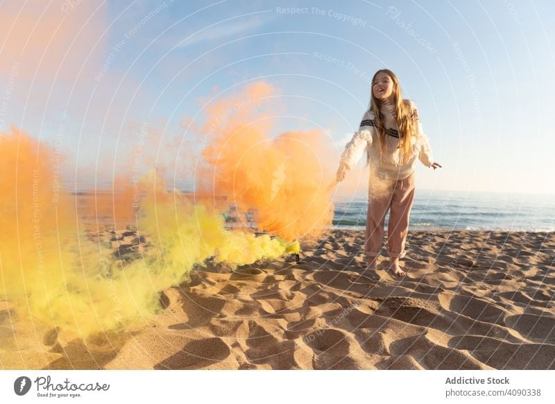Teen girl with smoke signal on beach teenager colored smiling sea sand waves lifestyle leisure rest relax casual stylish trendy fun coast shore glad pleasure