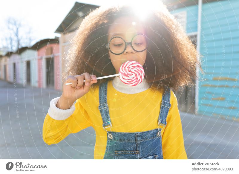 African American girl eating big lollipop african american black pretty cute sweet food beautiful tasty enjoying colorful holding hands candy happy funny mop
