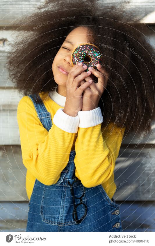 Young girl eating donuts with pleasure food young tasty people pretty person funny sugar cake bakery hungry unhealthy lifestyle cute colorful glazed joyful
