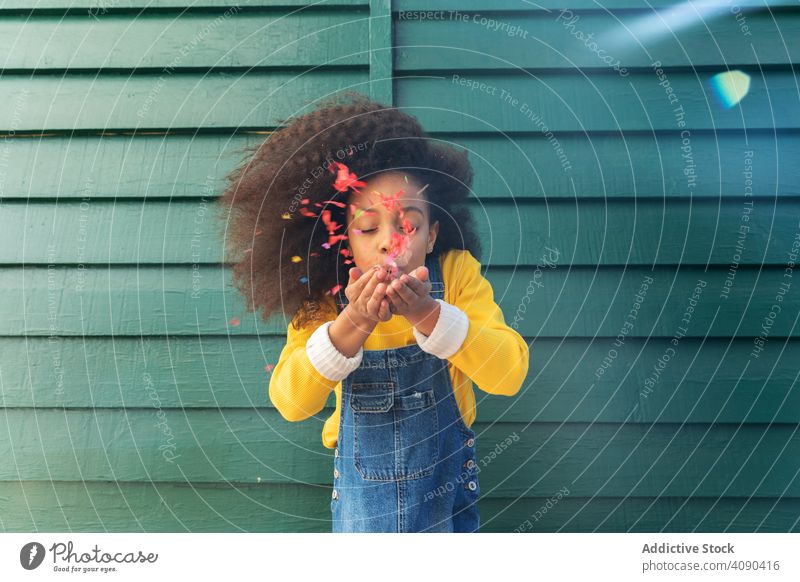 Girl blowing at rose petals girl african american romantic attractive standing cute pink happy people happiness person flowers funny child childhood curly loose
