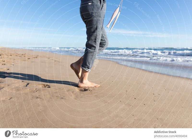 Smiling girl holding ribbons on beach sea accessory smiling barefoot sand showing waves sunny tourism vacation daytime kid child teen ocean water demonstrating