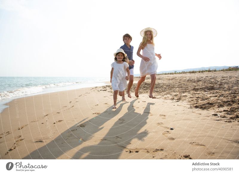 Kids running along seashore children beach summer vacation lifestyle happy ocean kids together happiness water sand people joy holiday beautiful childhood