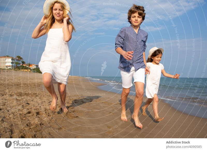 Kids running along seashore children beach summer vacation lifestyle happy ocean kids together happiness water sand people joy holiday beautiful childhood