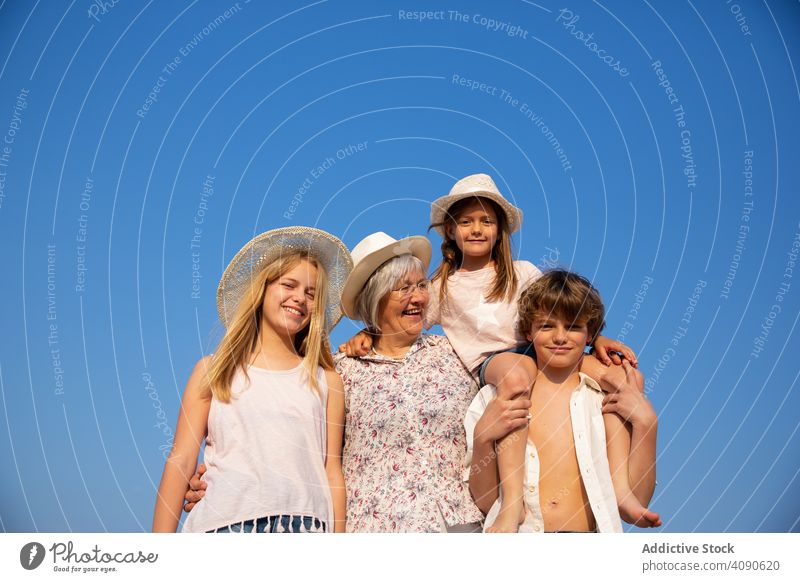 Grandmother and grandchildren standing together grandmother grandsons summer leisure holidays vacation family senior young girls boy woman aged happy kid