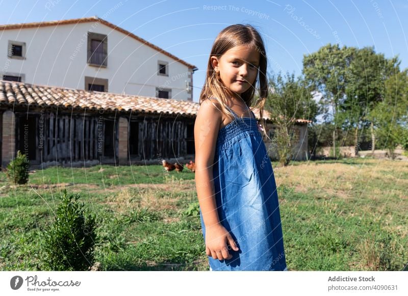 Little girl standing on farm yard summer vacation leisure holidays house beautiful nature happy field grass people country pretty rural cute child countryside
