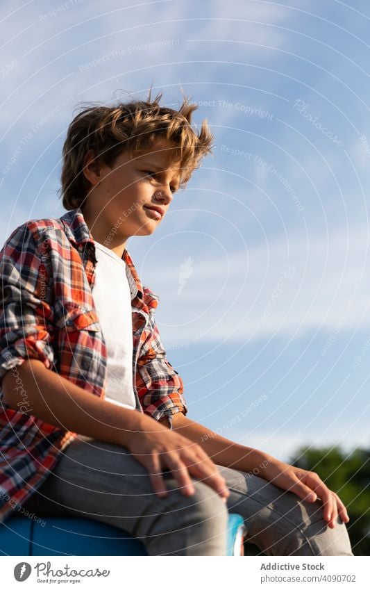 Boy sitting on tractor on farm boy field agriculture sky clouds sunny daytime teen kid child casual lifestyle leisure relax rest rural summer ranch rustic