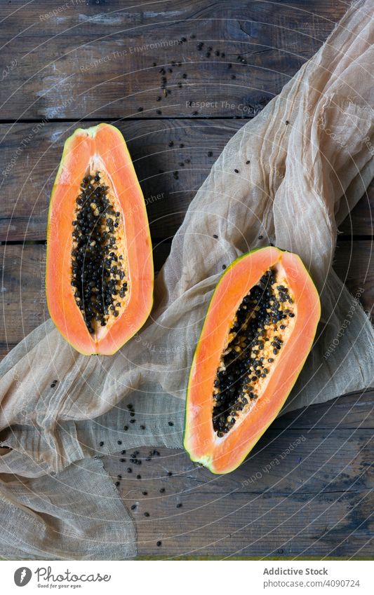 Halves sliced fresh papaya on wooden background half composition ripe juicy fruit seed fabric delicious tropical food dessert appetizing pulp natural sweet