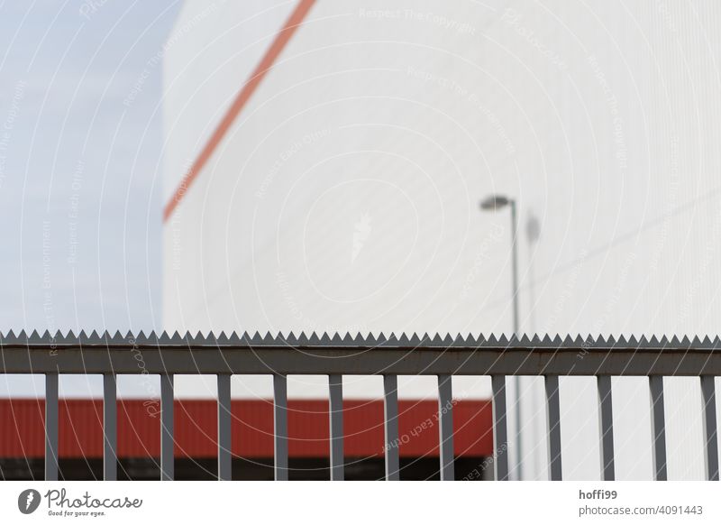Close-up of a lattice fence with a sawtooth crest closing off an industrial building Fence cordoned off guarded Protection shield Guard Barrier Metal Steel