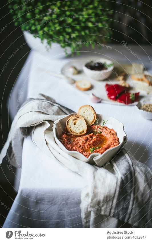 Syrian muhammara cream served in a bowl Dip Appetizer Peppers nuts Sirian cream cooking prepare delicious cool kitchen table cuisine orange food ingredient