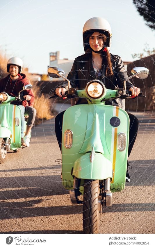 Young people riding motorcycles on city road helmet friendship scooter bike activity leisure street adventure travel enjoying transportation motorbike young