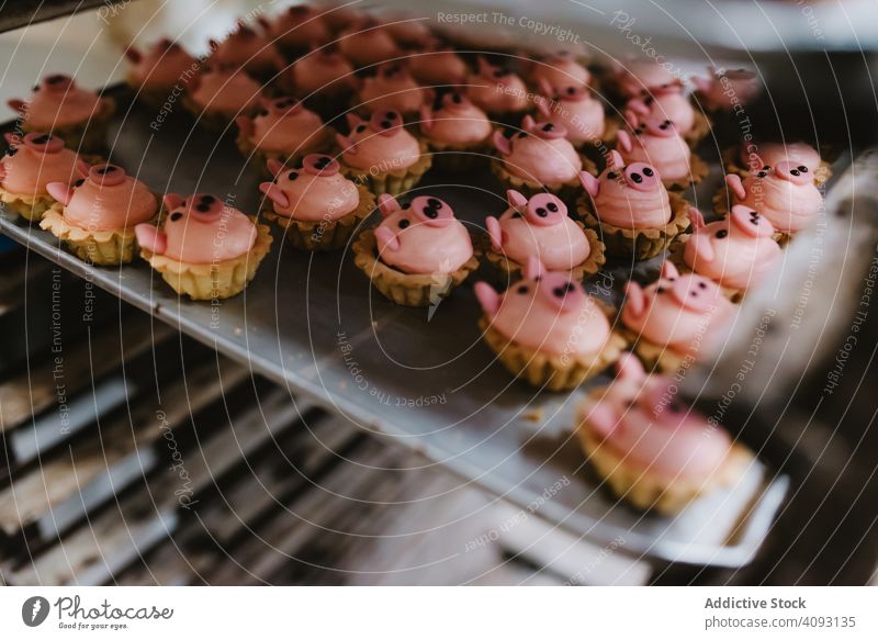 Tray with pig shaped desserts in bakery pastry rack tray symbol small pink cake ear snout food sweet fresh small business event preparation decor patisserie