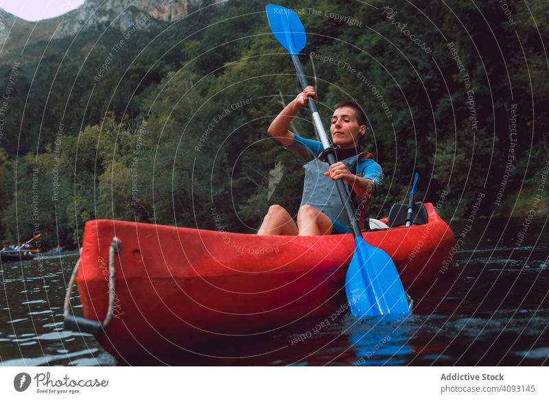 Young female kayaking on nature background woman paddle sport sella river spain adventure activity water tourism canoe lifestyle travel concentrated serious