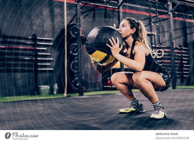 Muscular woman exercising with ball in gym exercise fitball training health club athletic muscular female sportswear workout fitness healthy body active