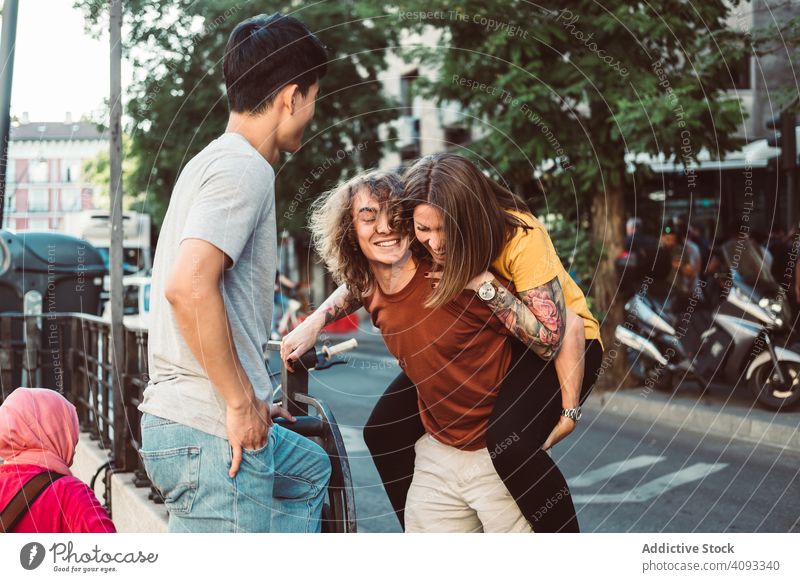 Carefree multiracial friends having fun on street piggyback playful carefree laugh stand city together summer diverse bonding happy friendship urban people
