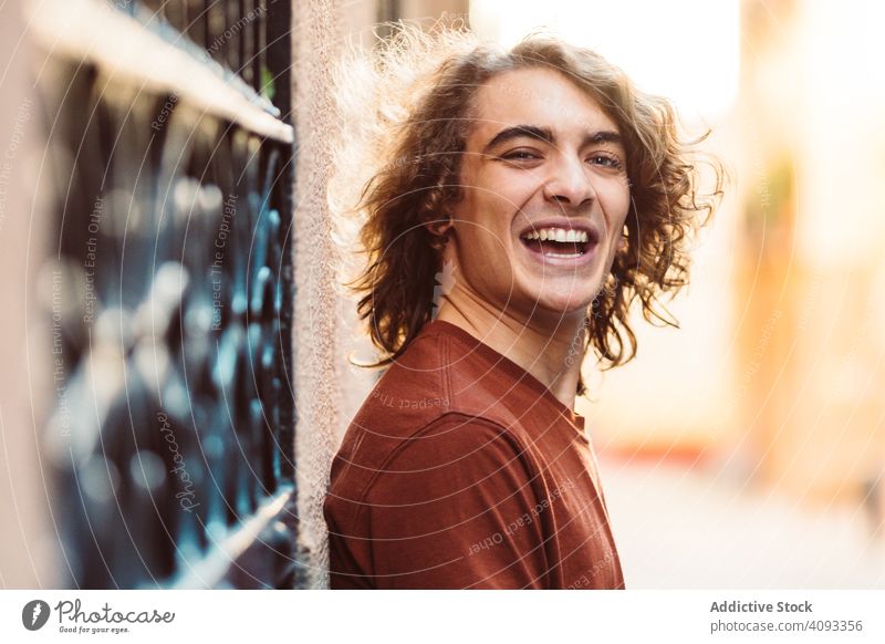 Positive handsome man smiling on street smile positive content human face confident long hair happy modern cheerful success satisfaction joy casual energy young