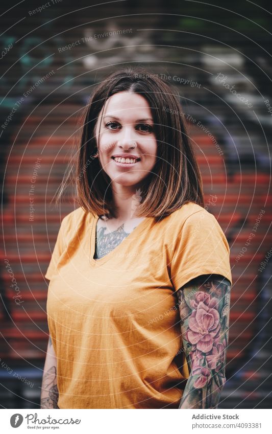 Cheerful tattooed woman smiling and standing on street smile cheerful hipster positive modern urban happy confident beautiful attractive charming t shirt