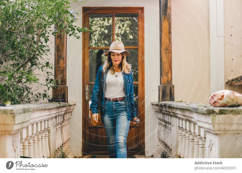 Woman walking on old porch woman house lifestyle leave doorway terrace architecture exterior trendy smile wooden glass content beautiful connection casual