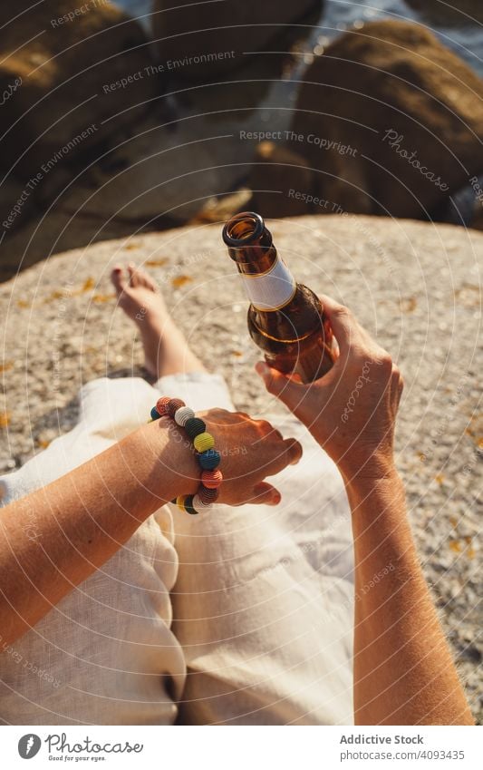 Woman relaxing and drinking beer at beach woman coast seaside lounge refreshment chill sunlight enjoy solitude bottle travel alcohol holidays trip vacation