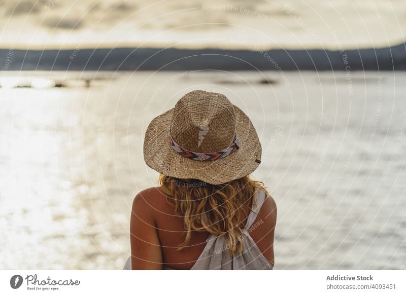 Blond lady resting at seaside woman seascape coast picturesque harmony cloud solitude peace enjoy travel calm tranquil hat trip vacation ocean beautiful
