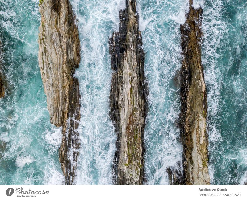 Stone ridges on high seas in stormy day ocean scenic nature nautical dramatic rocky water coast travel tourism natural dangerous turquoise aquatic mountain