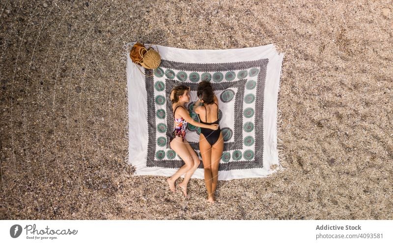 Girlfriends lying on beach relaxing women together vacation resort best friend holidays tourism friendship female happy cheerful pretty attractive positive