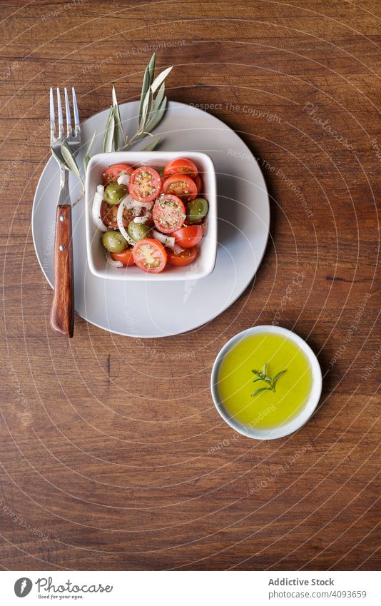 Fresh vegetarian meal on plate salad cherry tomato vegetable fresh oil organic olive bowl sauce shabby wood food healthy dinner green gourmet diet cuisine