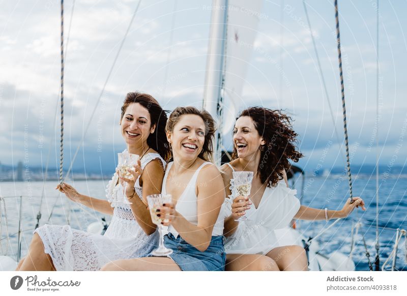 Cheerful friend with wine having fun on yacht women bachelorette party sea engaged celebration female bridesmaid group lifestyle leisure rest relax sailboat
