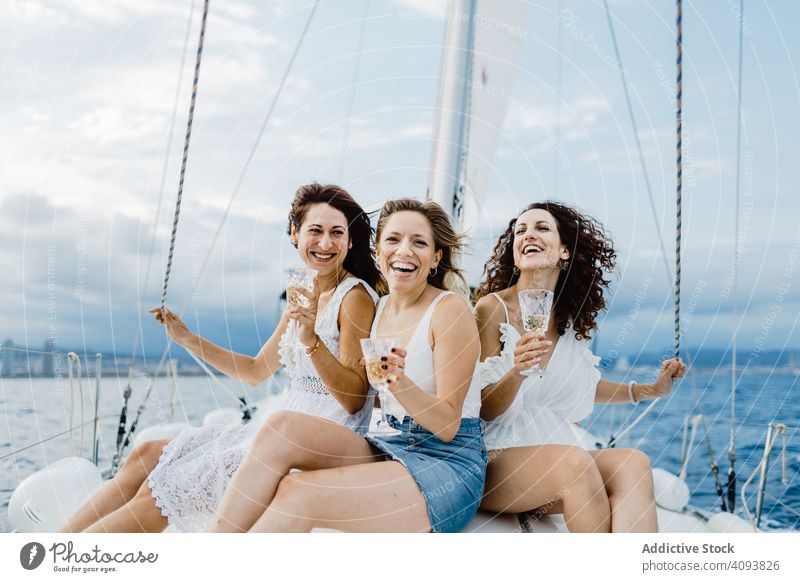 Cheerful friend with wine having fun on yacht women bachelorette party sea engaged celebration female bridesmaid group lifestyle leisure rest relax sailboat