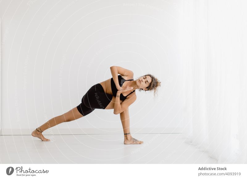Sportive woman performing yoga pose in room practicing position relaxation exercise beautiful fitness sport leisure female workout meditate wellness sportswear