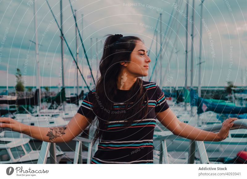 Smiling female walking standing on busy urban pier woman wharf harbor yacht enjoy boat sea nature happy summer young leisure seaside marina water transport