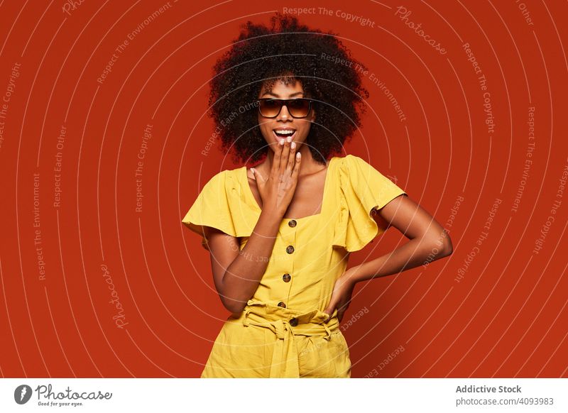 Bright ethnic woman with hands behind head smiling at camera trendy colorful bright content modern cool lady black confident model african american casual