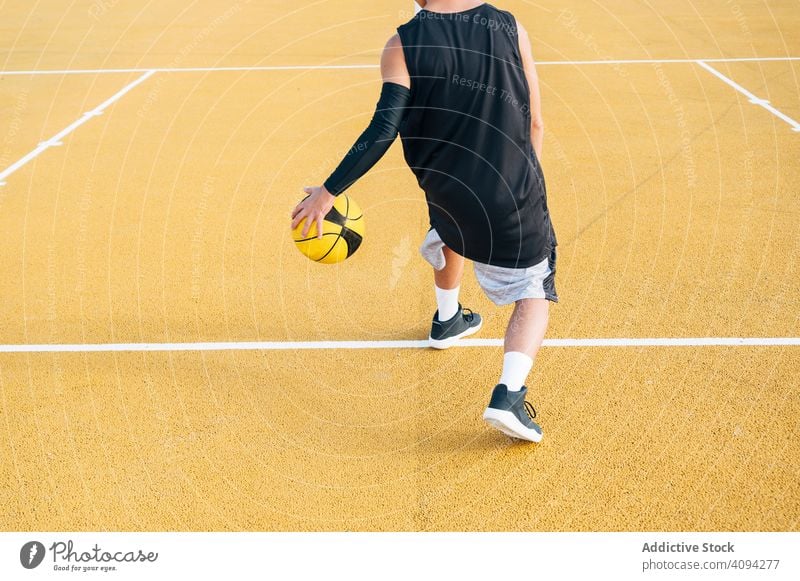 crop Young man and ball playing on basketball court outdoor. athlete competition sports equipment adult recreation action active activity asphalt athletic city