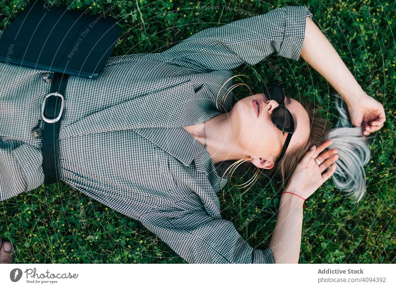 Woman with tablet in stylish suit lying in grass businesswoman rest green break using relaxation trendy communication manager career entrepreneur screen gadget