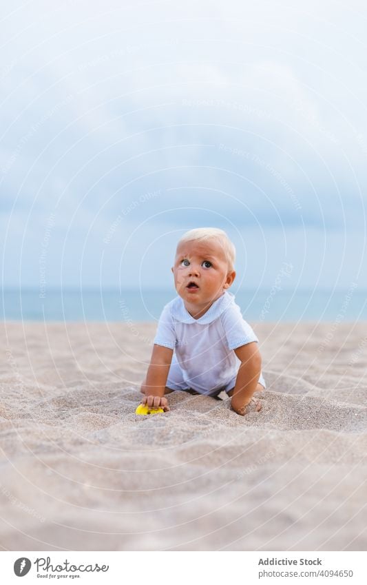 Blond baby on the beach summer kid space copy face outside caucasian ethnicity blond hair portrait happiness play happy sea vacation one shore coast sand little