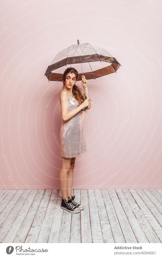 Young girl posing with an umbrella on pink background summer spring indoor accessories parasol space copy looking women concept protection lifestyle studio one